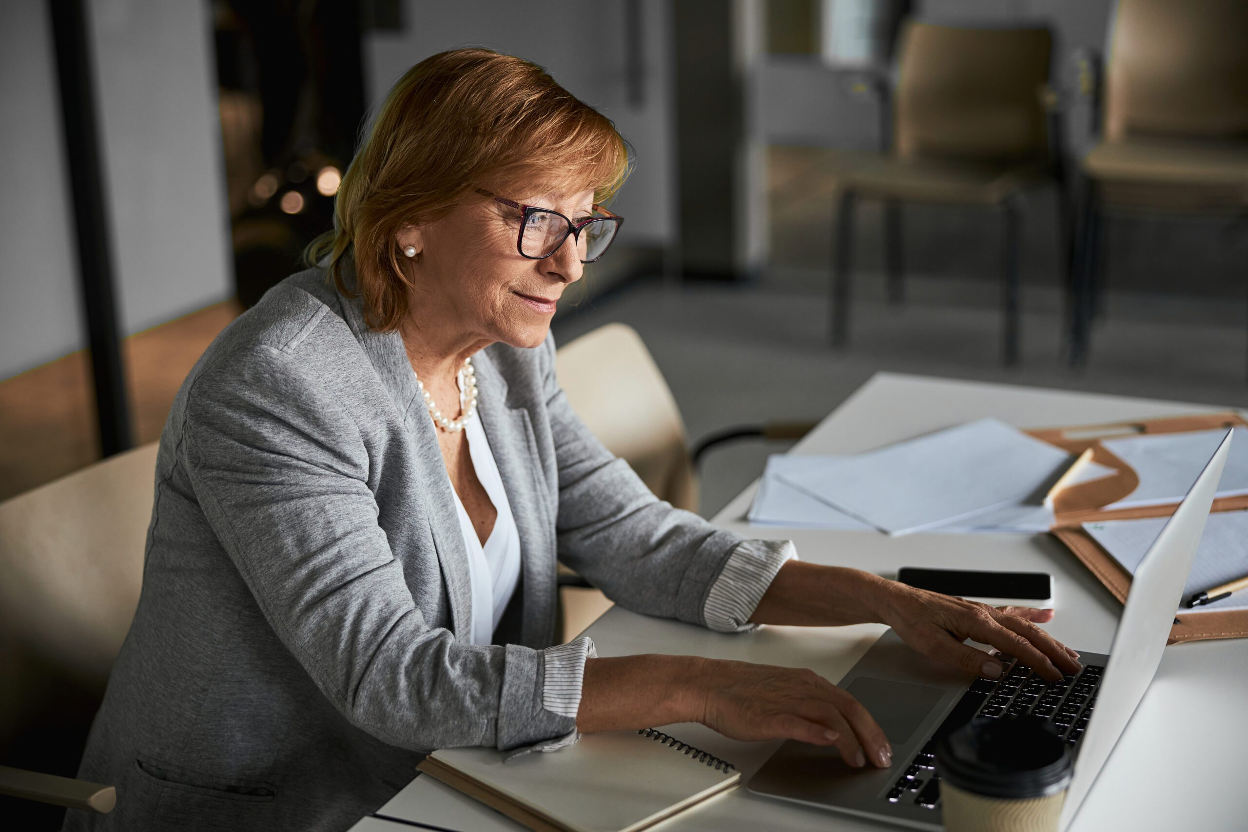 Pleased female company director typing on laptop keyboard Pleased female company director typing on laptop keyboard