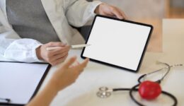 Female doctor consulting the treatment plan on tablet to her patient.