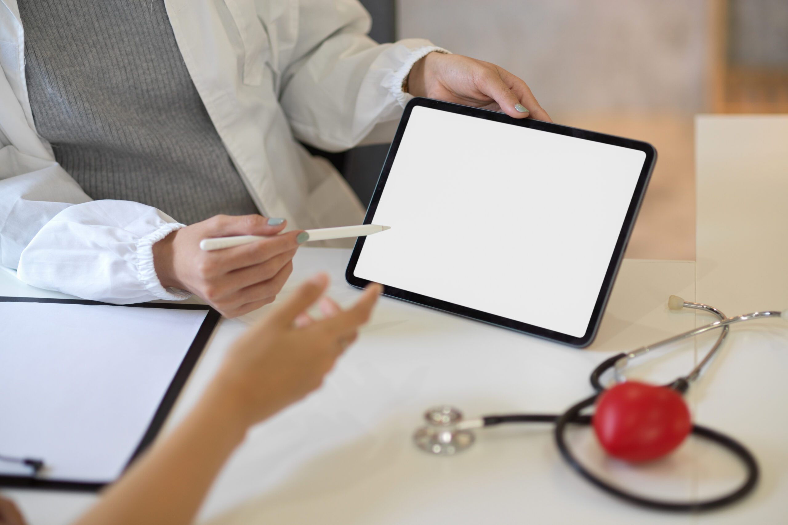 Female doctor consulting the treatment plan on tablet to her patient.
