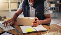 Hands, man typing with box for distribution of inventory management, online order and stock. Person, keyboard and package report of supply chain, quality control and information for delivery schedule
