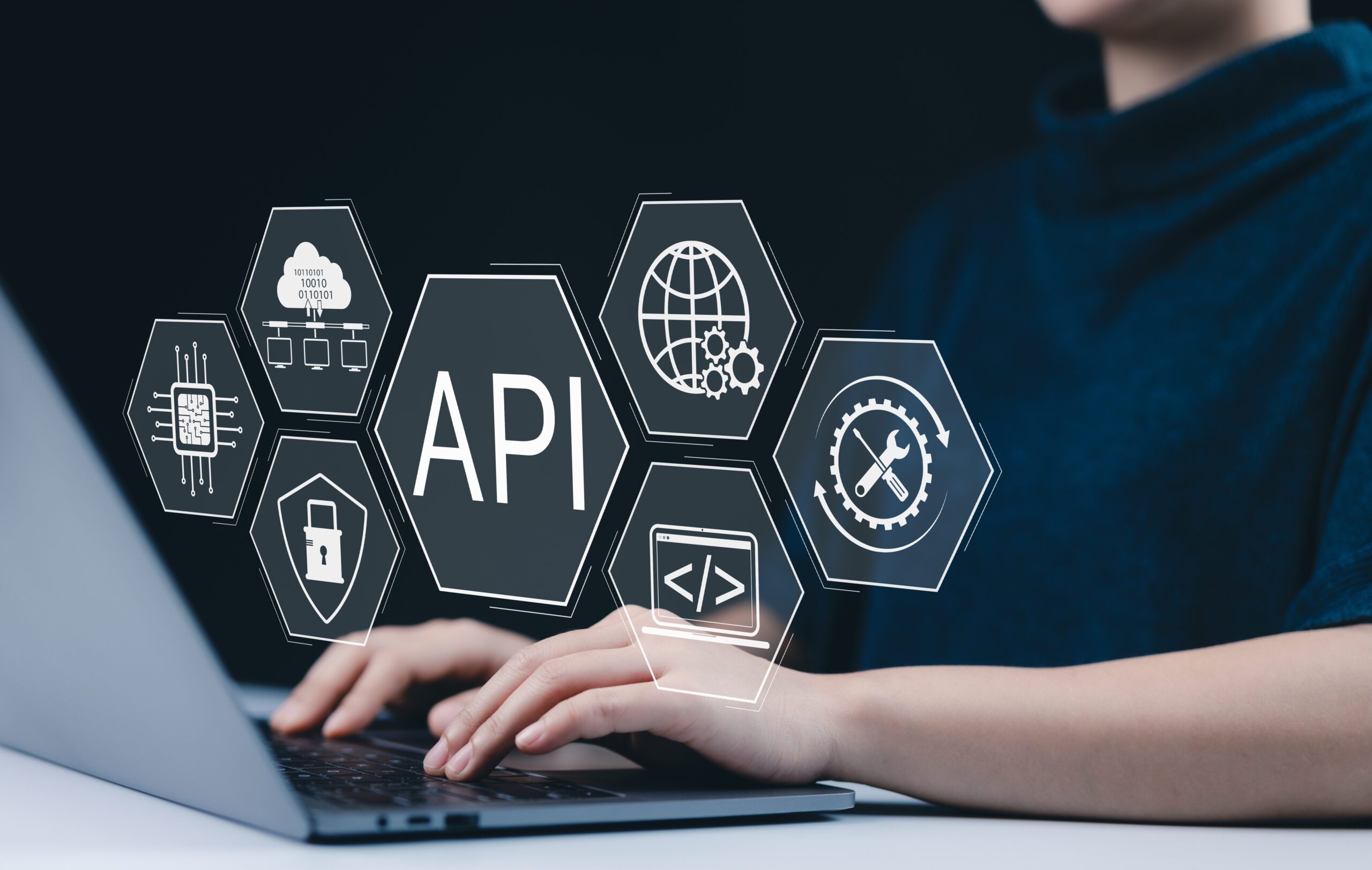API Application Programming Interface Concept. A person types on laptop, with digital icons representing API development, security, and cloud computing technology. networking application software tool API Application Programming Interface Concept. A person types on laptop, with digital icons representing API development, security, and cloud computing technology. networking application software tool