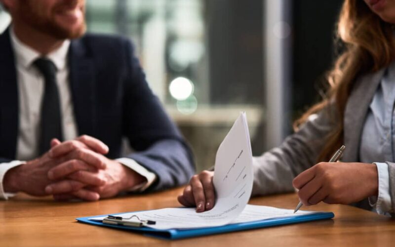Documents, contract and business people writing signature for deal, partnership or legal paperwork in night office. Paper of lawyer woman, notary or partner hands for policy, compliance and agreement Data governance framework ensuring GDPR and CCPA compliance with secure and compliant data solutions.